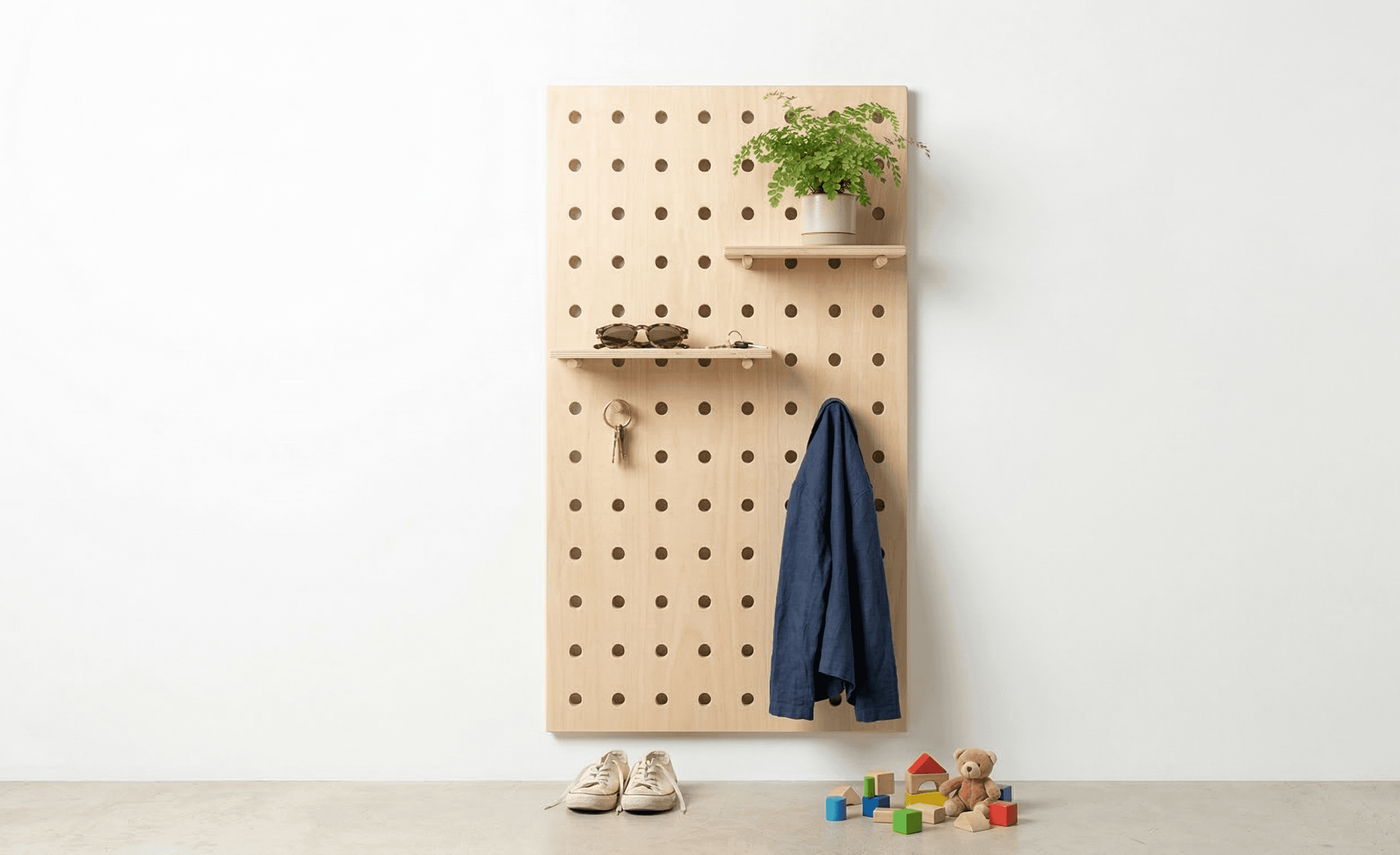 Pegboard in entryway with shelves, sunglasses, jacket, plant, and kids toys